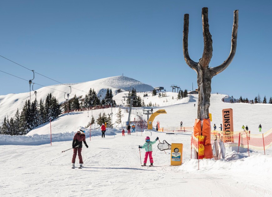 Eine Mutter mit Tochter auf den Skiern in der tief verschneiten Winterlandschaft im Skigebiet Großarl.