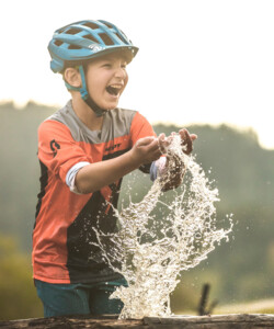 Ein Junge erfrischt sich mit Wasser und hat Spaß